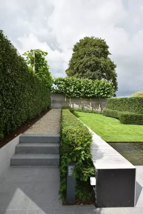 Strak aangelegde tuin met border, gazon en zithoek, gerealiseerd door Boomes Tuinonderhoud
